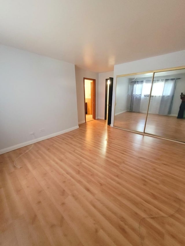 unfurnished bedroom with light hardwood / wood-style flooring and a closet