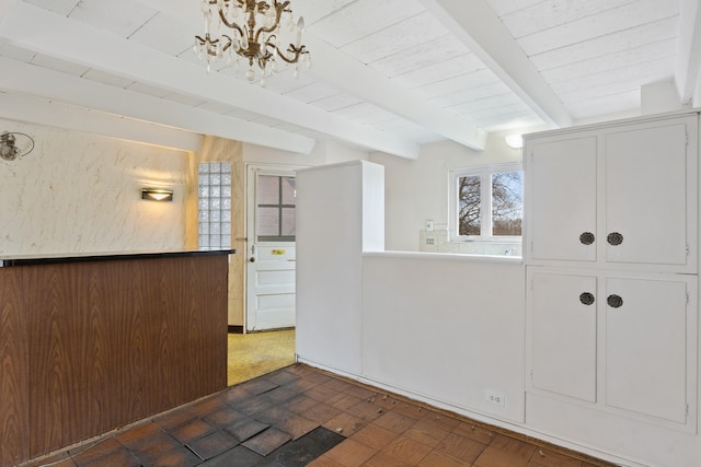 interior space featuring beamed ceiling and a notable chandelier