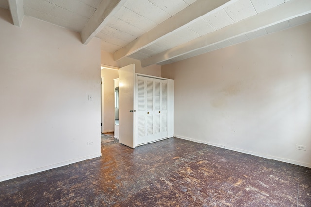 unfurnished bedroom featuring beam ceiling, a closet, and wooden ceiling