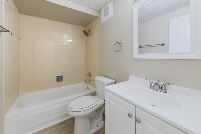 full bathroom with vanity, a textured ceiling, wood-type flooring, toilet, and tiled shower / bath