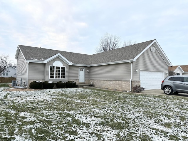 ranch-style home with central AC unit and a garage