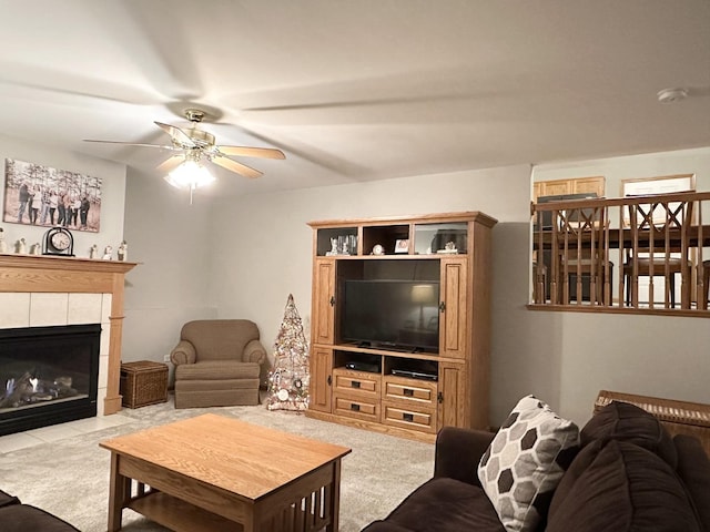 living room featuring ceiling fan, light colored carpet, and a fireplace