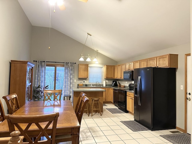 kitchen featuring light tile patterned flooring, pendant lighting, high vaulted ceiling, and black appliances