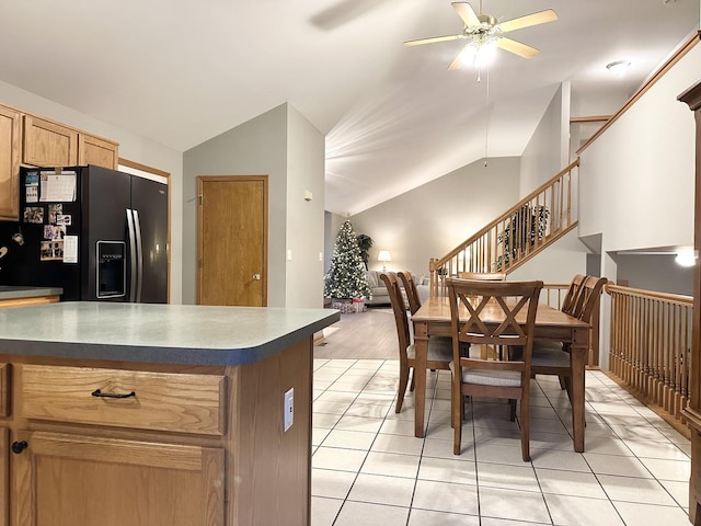 kitchen with ceiling fan, black fridge with ice dispenser, light tile patterned floors, and vaulted ceiling