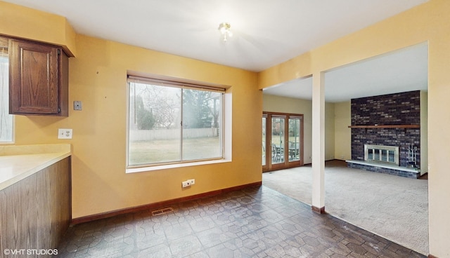 interior space with a brick fireplace and dark colored carpet