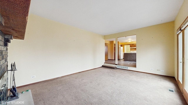 unfurnished living room featuring a fireplace and carpet floors