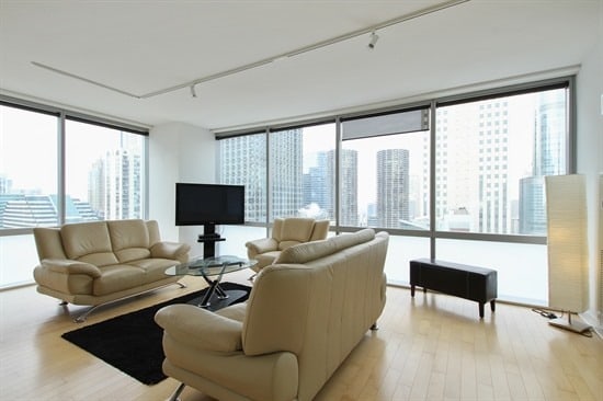 living room with light wood-type flooring, track lighting, and expansive windows