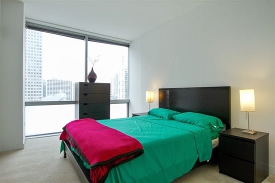 carpeted bedroom featuring a wall of windows and multiple windows