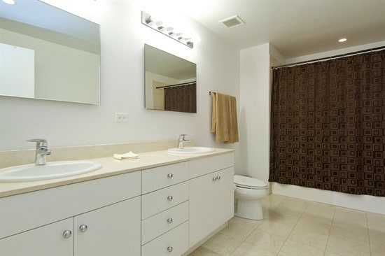 bathroom featuring tile patterned flooring, a shower with curtain, vanity, and toilet