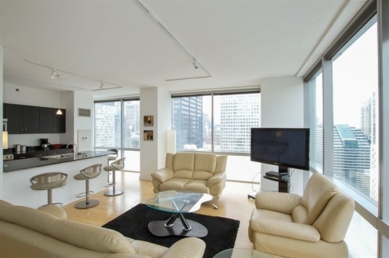 living room with plenty of natural light, expansive windows, and rail lighting