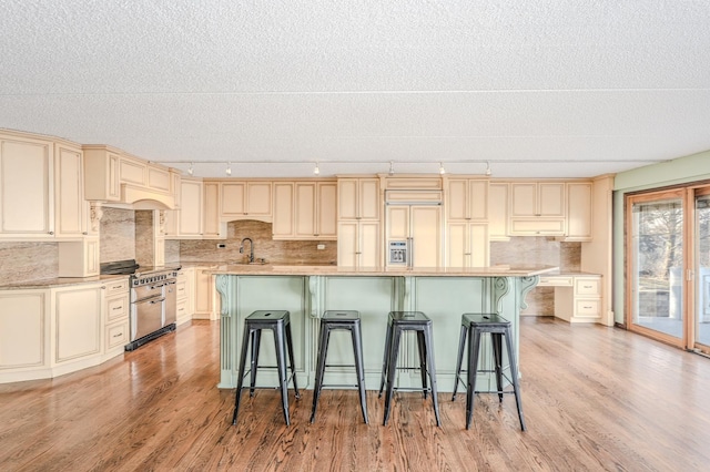 kitchen with a breakfast bar, cream cabinetry, and track lighting