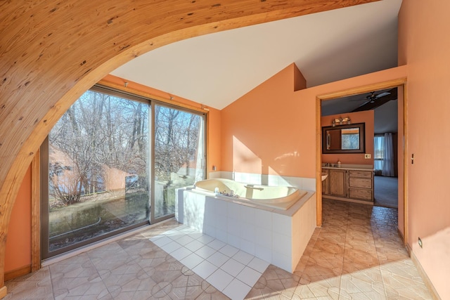 bathroom featuring ceiling fan, sink, tile patterned flooring, tiled bath, and lofted ceiling