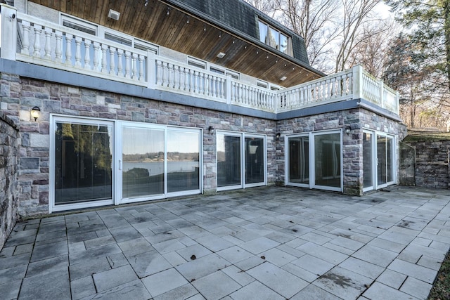 back of house featuring a balcony and a patio