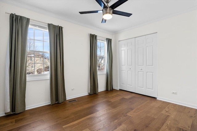 unfurnished bedroom featuring dark hardwood / wood-style flooring, a closet, ceiling fan, and ornamental molding