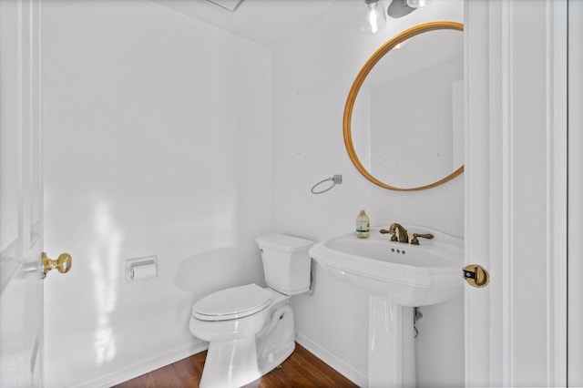 bathroom with hardwood / wood-style floors, toilet, and sink