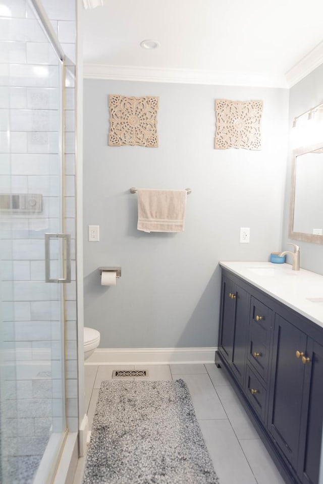 bathroom with tile patterned flooring, vanity, ornamental molding, and toilet