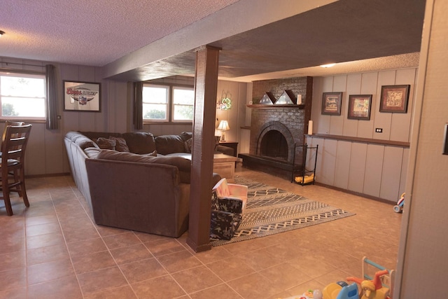 living room featuring tile patterned floors, a textured ceiling, wooden walls, and a brick fireplace