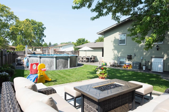 view of patio with cooling unit, a fenced in pool, and an outdoor living space with a fire pit