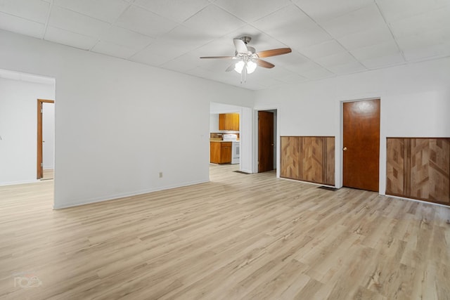 empty room featuring ceiling fan, a paneled ceiling, and light wood-type flooring