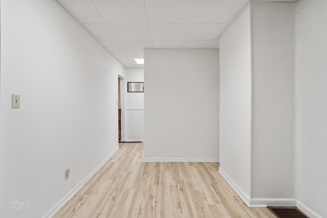 empty room featuring light hardwood / wood-style floors and a drop ceiling