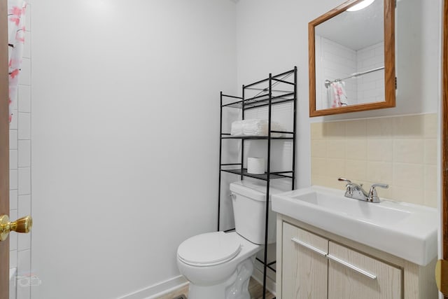 bathroom featuring vanity, toilet, curtained shower, and tile walls