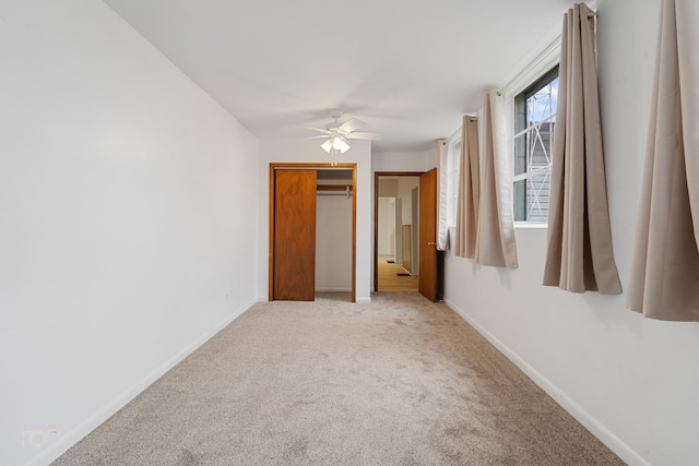 unfurnished bedroom featuring light carpet, ceiling fan, and a closet