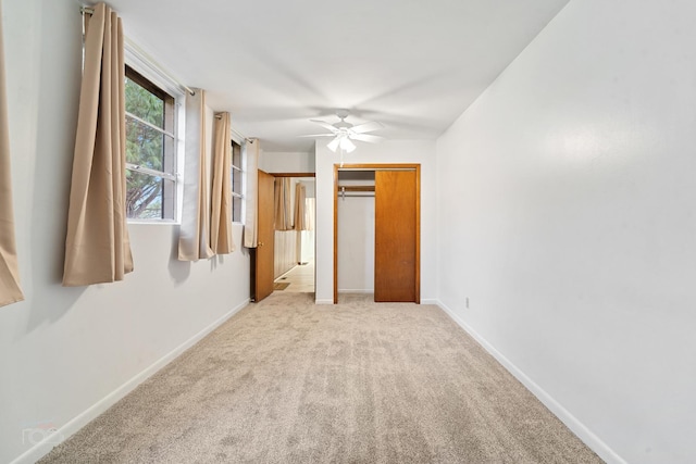 unfurnished bedroom with ceiling fan and light colored carpet