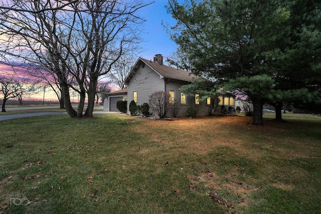 property exterior at dusk featuring a lawn and a garage