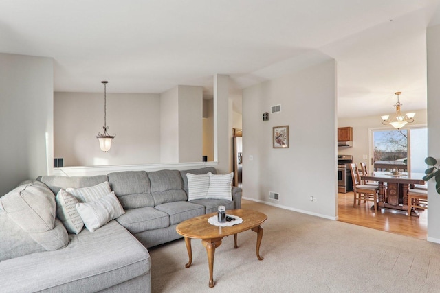 living room featuring a chandelier and light colored carpet