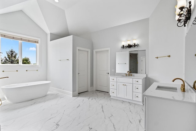 bathroom featuring vanity, lofted ceiling, and a tub