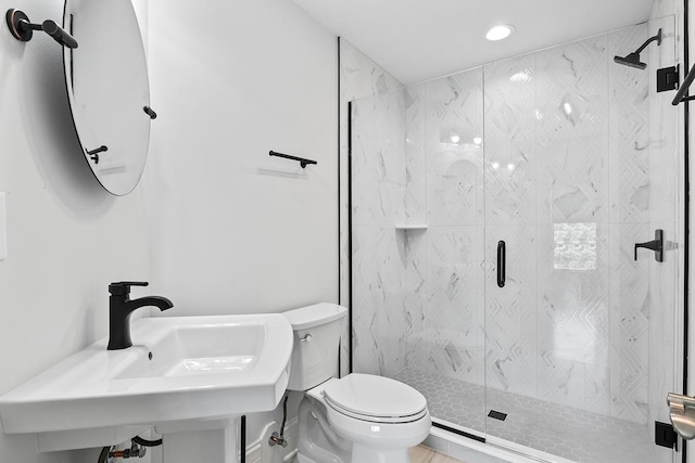 bathroom featuring sink, an enclosed shower, and toilet