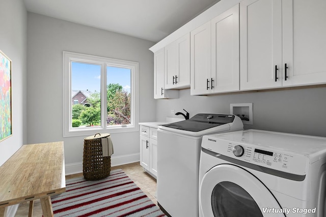 laundry room featuring cabinets, washer and clothes dryer, and light tile patterned floors