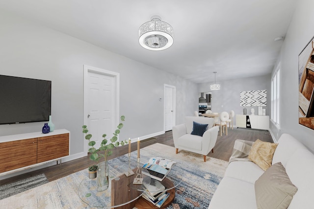 living room featuring dark wood-type flooring and a notable chandelier