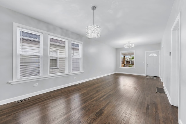 unfurnished room featuring dark hardwood / wood-style flooring and a chandelier