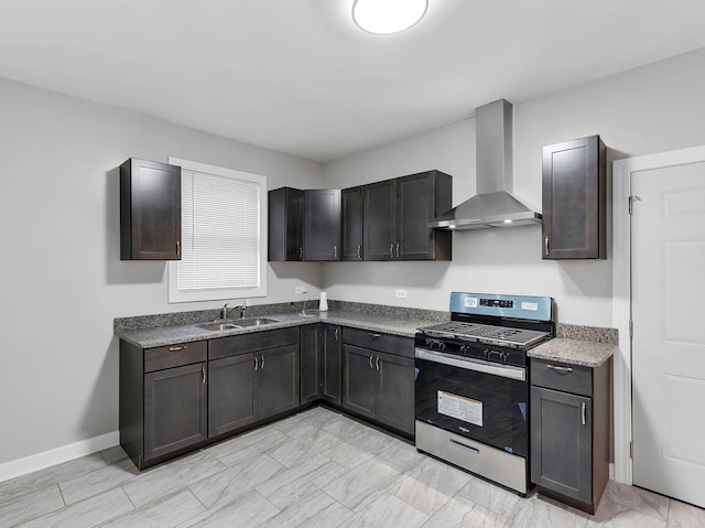 kitchen featuring sink, stainless steel gas stove, dark brown cabinetry, and wall chimney range hood