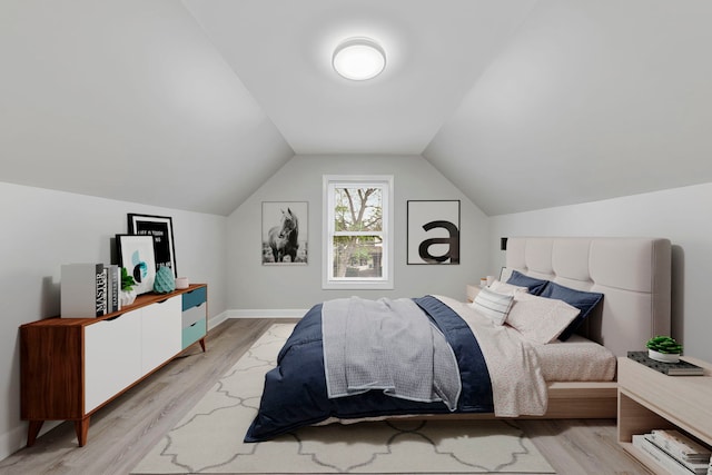 bedroom featuring light hardwood / wood-style floors and lofted ceiling