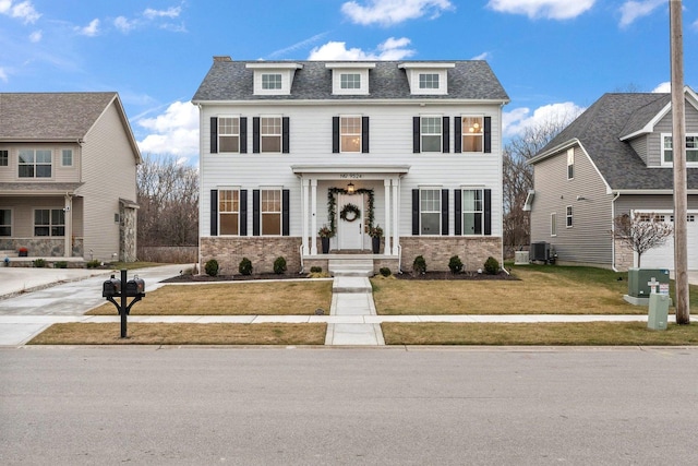 colonial inspired home with a front lawn and central AC