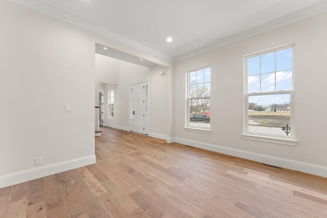 empty room with light wood-type flooring and ornamental molding