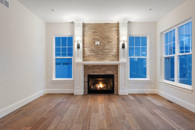 unfurnished living room with light wood-type flooring and a fireplace