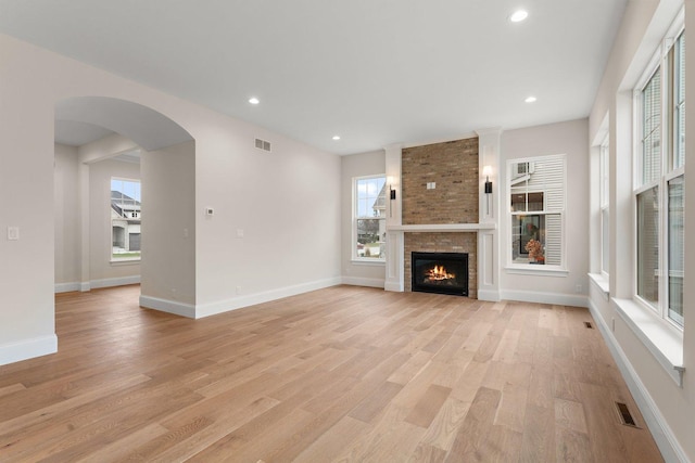 unfurnished living room featuring a fireplace and light hardwood / wood-style flooring