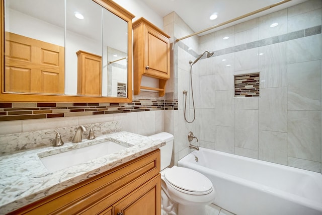 full bathroom featuring vanity, tiled shower / bath combo, tasteful backsplash, and toilet