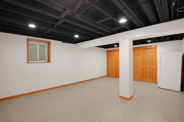 basement featuring white fridge and carpet floors