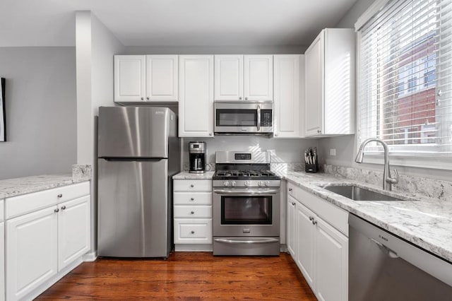 kitchen featuring white cabinets, light stone counters, sink, and stainless steel appliances