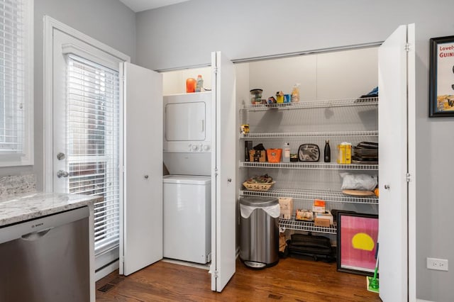 pantry featuring stacked washer / drying machine