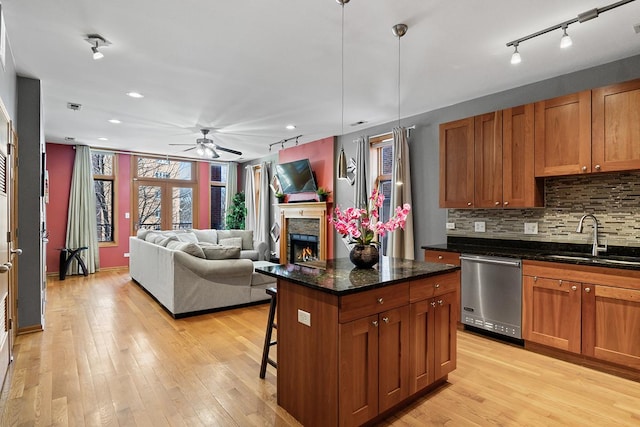 kitchen with pendant lighting, stainless steel dishwasher, a center island, sink, and a breakfast bar area