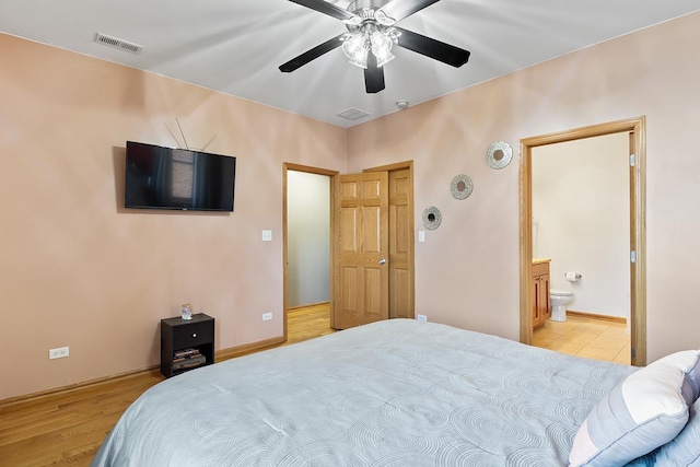 bedroom featuring ceiling fan, ensuite bath, and light hardwood / wood-style floors