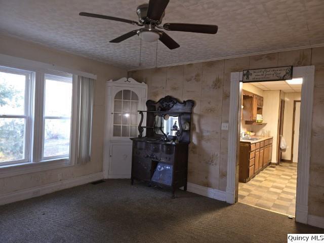 interior space with ceiling fan, a fireplace, light carpet, and a textured ceiling