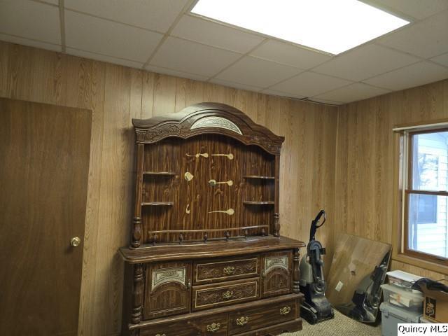 interior space with wooden walls and a drop ceiling