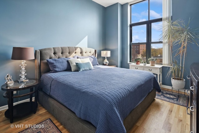 bedroom with baseboards and wood finished floors