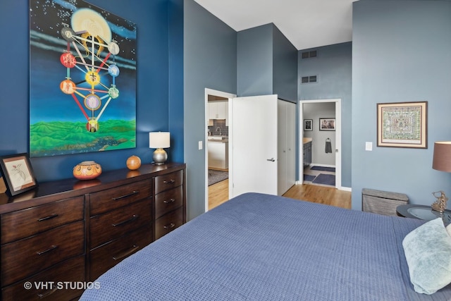 bedroom with a sink, visible vents, wood finished floors, and ensuite bathroom